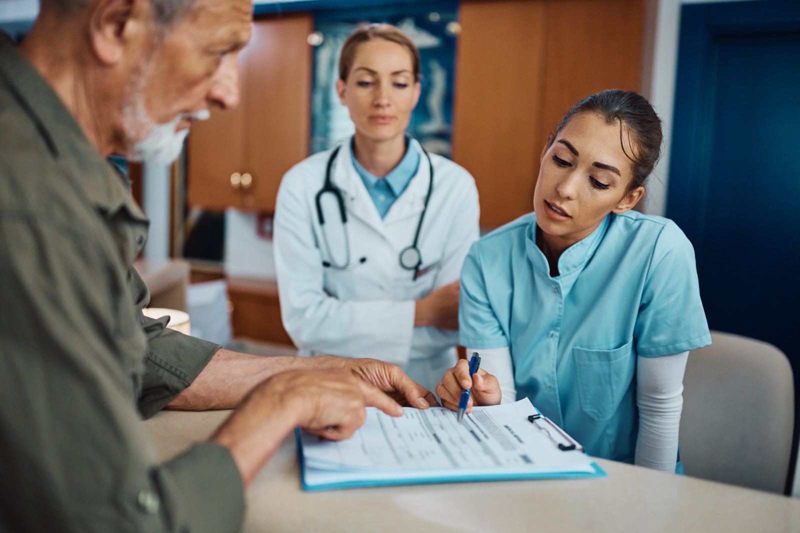 Medical practice front desk staff reviewing a patient's billing paperwork